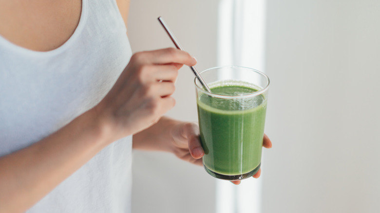 Hands holding green smoothie