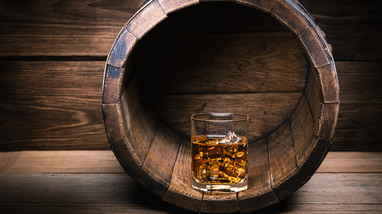 glass of whiskey inside barrel