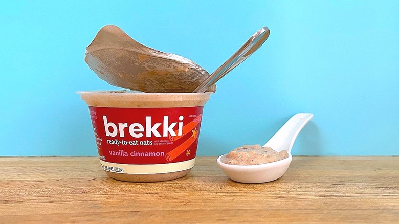 Container and spoonful of Brekki Vanilla Cinnamon-flavored ready-to-eat oats