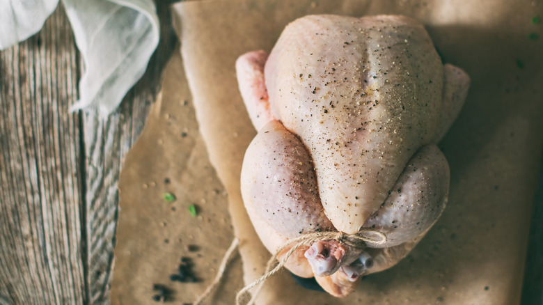 Trussed chicken seasoned with salt and pepper