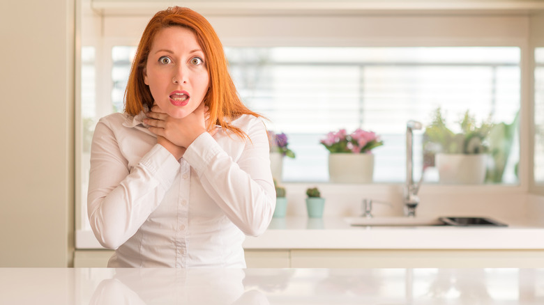 red-headed woman chocking in kitchen