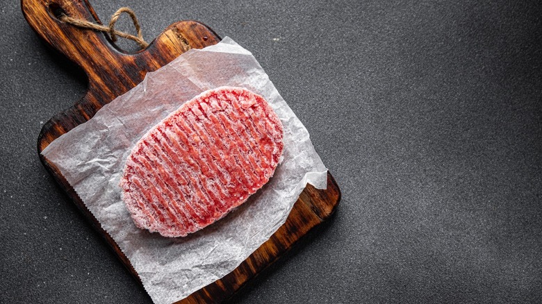 Frozen meat on wooden slab