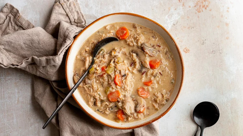 Creamy chicken and wild rice soup in bowl with linens