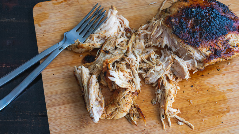 Shredded chicken on cutting board