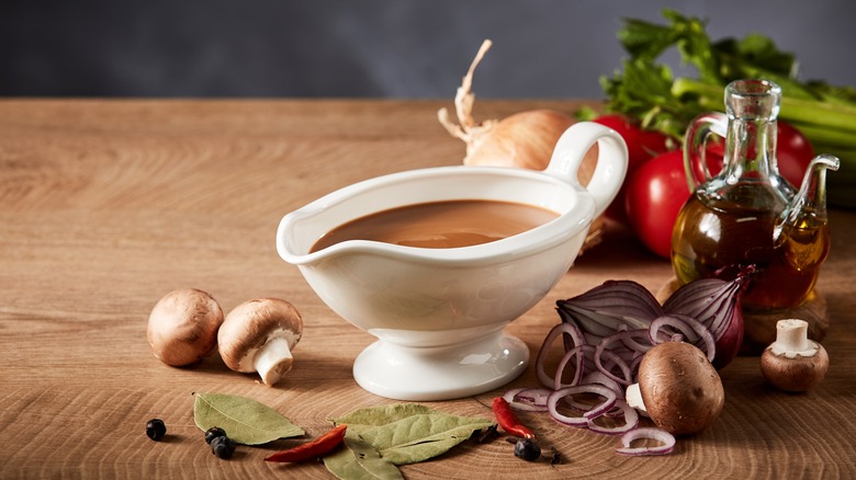 brown gravy in white pitcher wood table