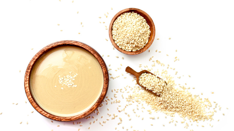 tahini paste and sesame seeds wood bowls