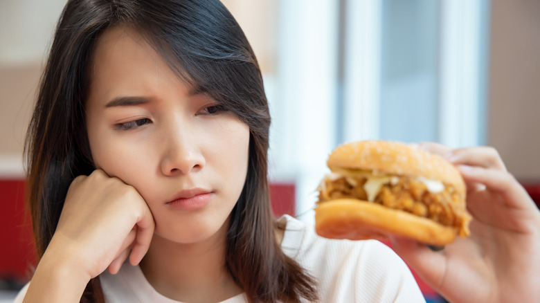 sad woman with chicken sandwich