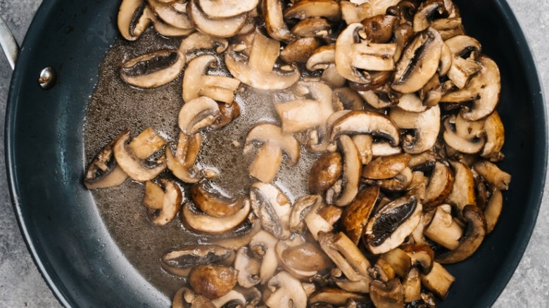 Sautéing mushrooms in a pan