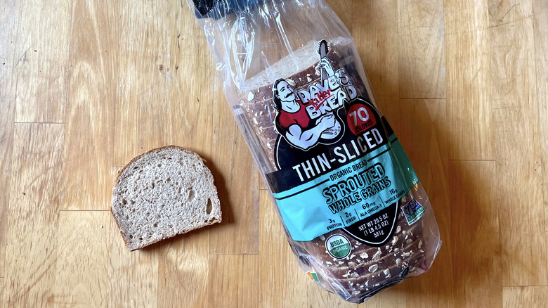 slice of bread next to Sprouted Whole Grains loaf