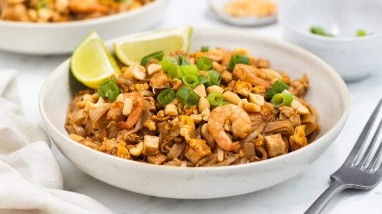 Shrimp pad thai with lime wedges