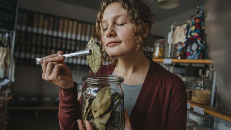 Woman smelling dried bay leaf