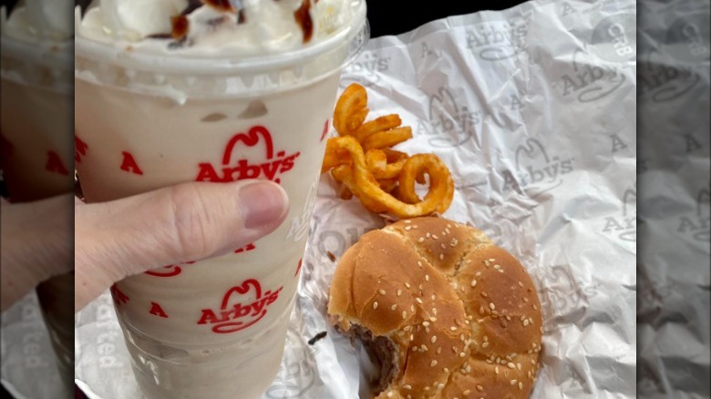 Hand holding Arby's milkshake