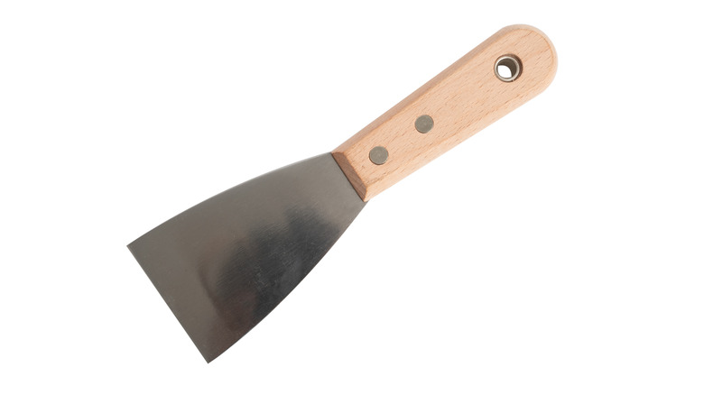 Wedge-shaped metal spatula with a wooden handle