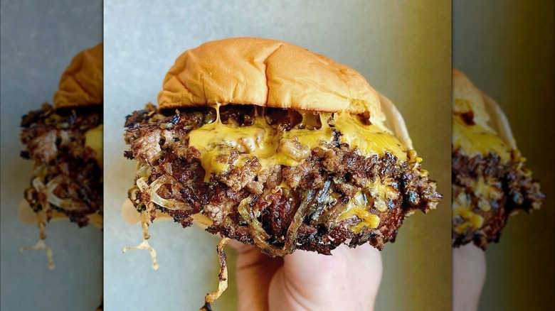 Easey's Oklahoma fried onion burger, held in someone's hand