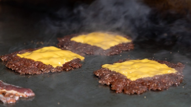 Smash burgers with cheese slices melting on top of them