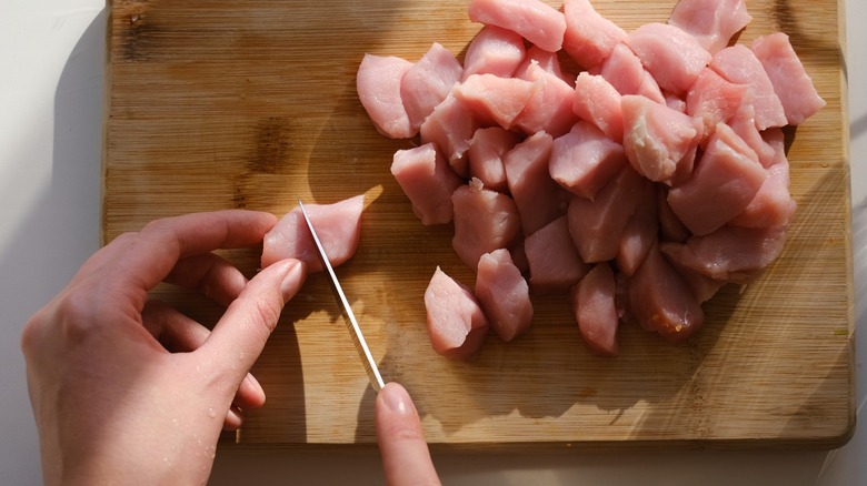 Chopping chicken on wooden board