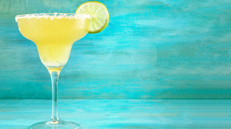 a glass of margarita with a lemon slice