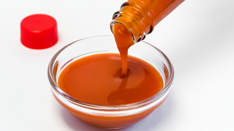 Pouring hot sauce into bowl