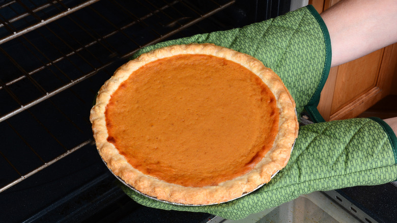 taking pumpkin pie out of oven