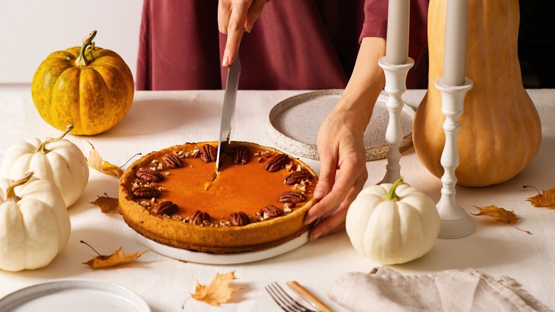 cutting pumpkin pie with knife