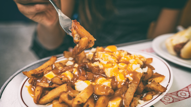 person eating poutine with fork