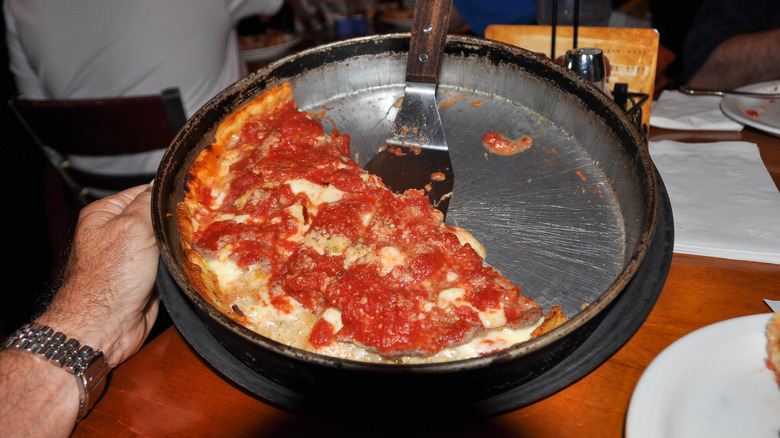 person holding pizza in pan