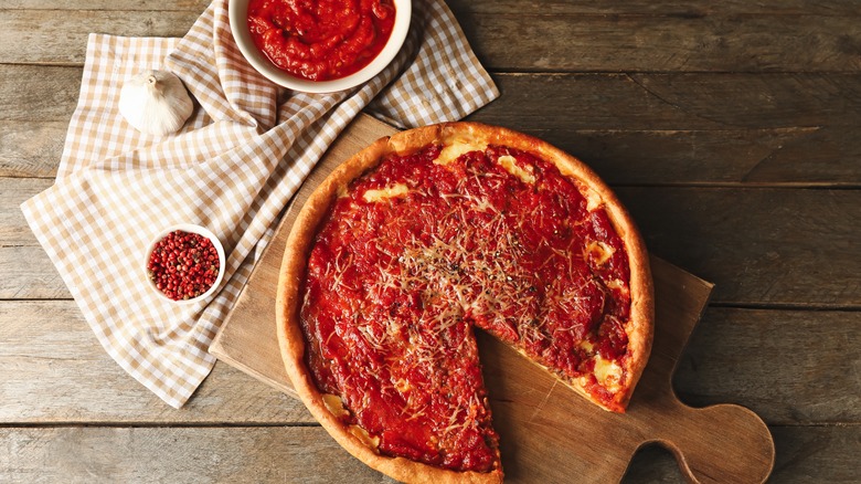 deep dish pizza and bowl of sauce