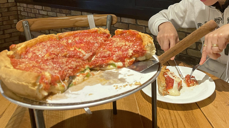 person eating deep dish pizza