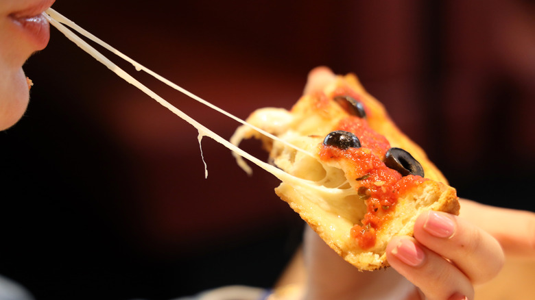 person eating deep dish pizza