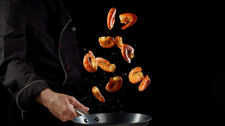 Shrimp flying off pan