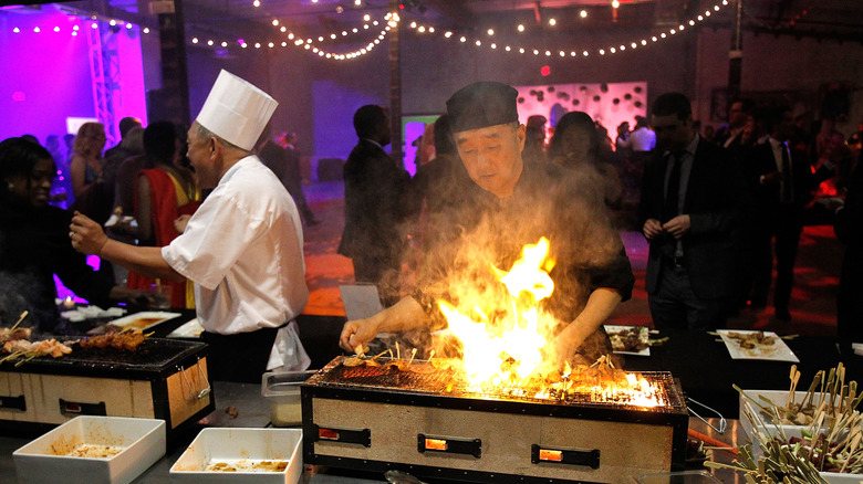 Chef grilling in dark room