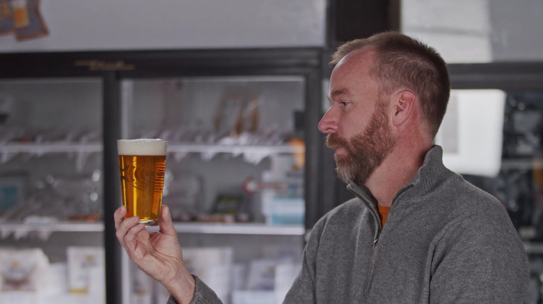 Man examining glass of beer