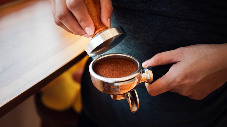 Coffee ground tamper in hands