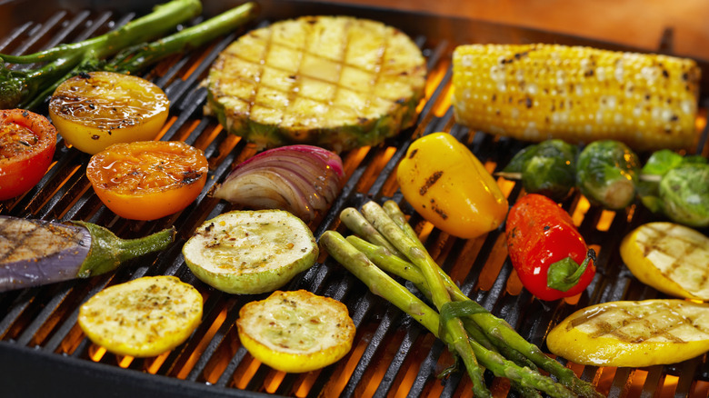 An assortment of vegetables grilling over an open flame