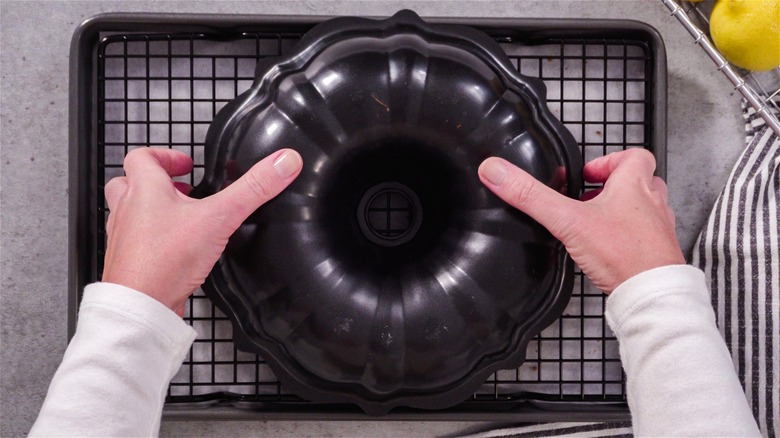 Hands removing cake from Bundt pan 