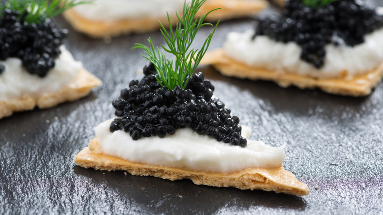 black caviar on cracker triangles with cream cheese