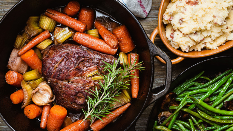 Roast in cast iron pan with veggies and side dishes.