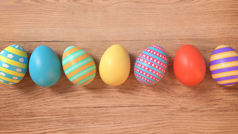 Colorful Easter eggs linked up on a wooden table