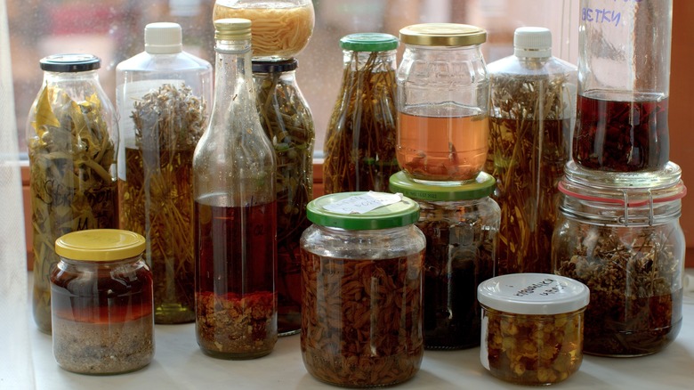 various herbal infusions in bottles and jars