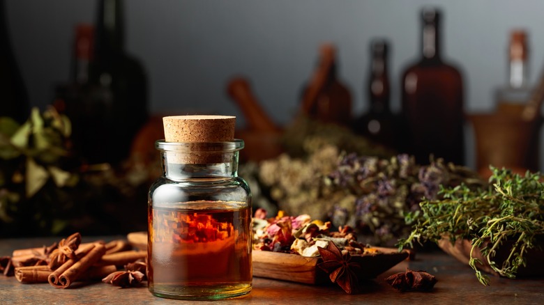 bottle of tincture with various dry herbs and spices