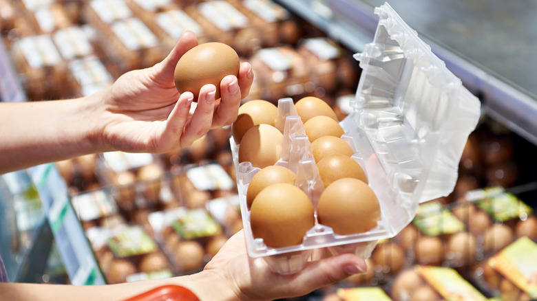 A person checking eggs at a supermarket