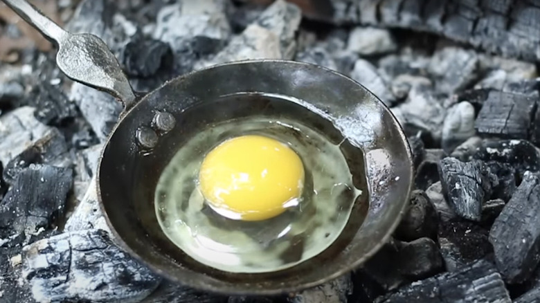 cooking a single egg over a campfire