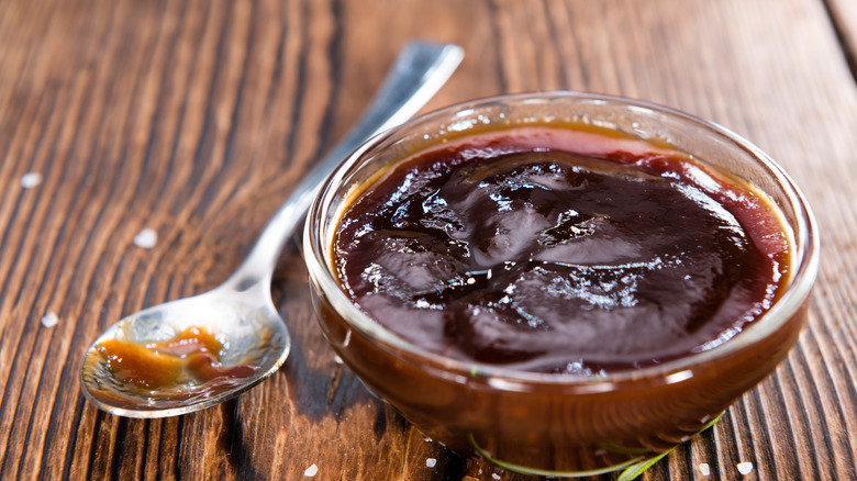 Ramekin of barbecue sauce on wood