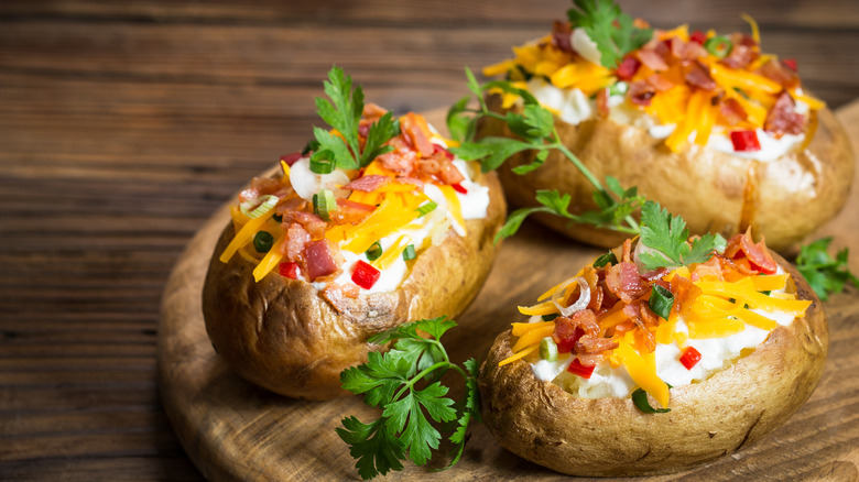 three baked potatoes with toppings