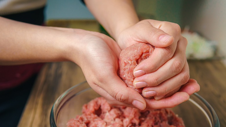 Hands making burger patty