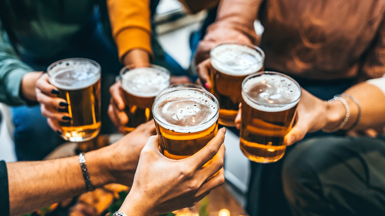 group toasting with beer pints