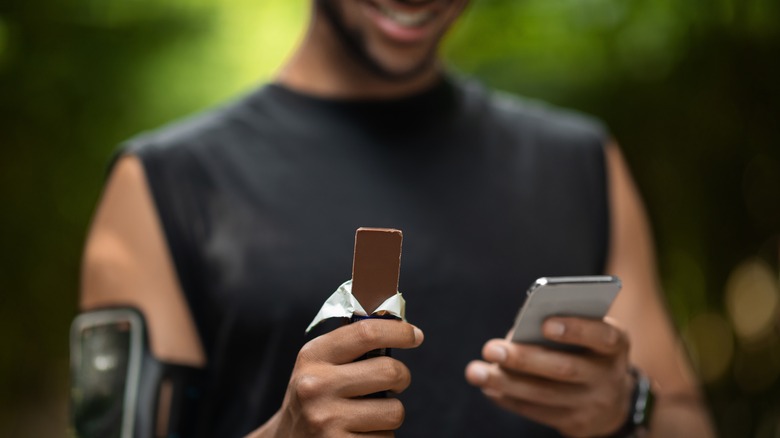 Man eating chocolate while on phone