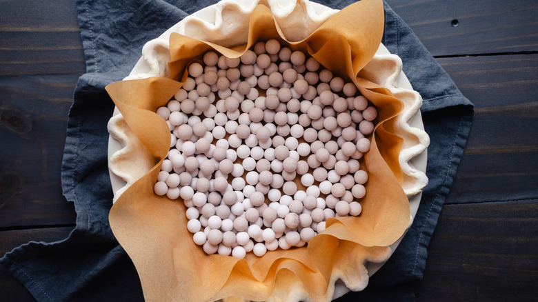 pie crust filled with parchment paper and weights for bling baking