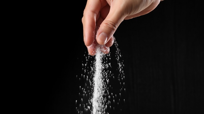 person sprinkling sugar