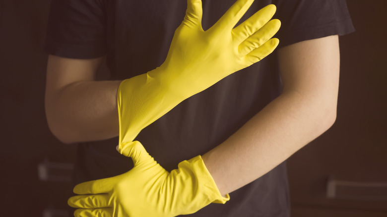 Person putting on rubber dish gloves